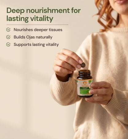 Woman taking an Amalaki Organic tablet for daily vitality