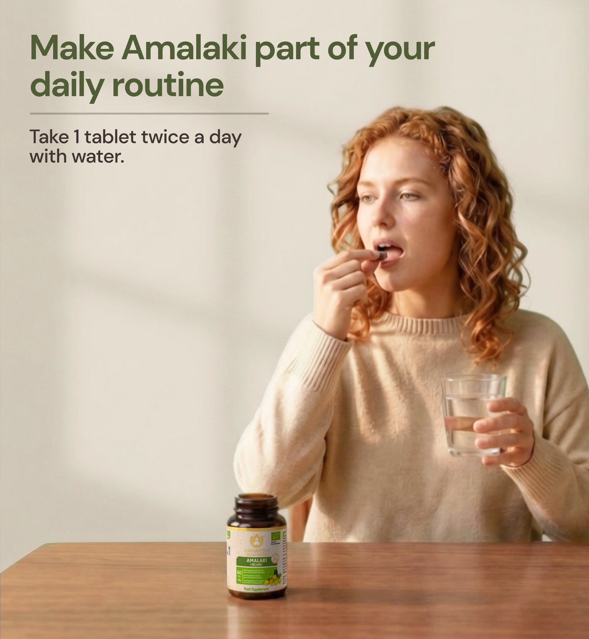 Woman taking an Amalaki tablet with water
