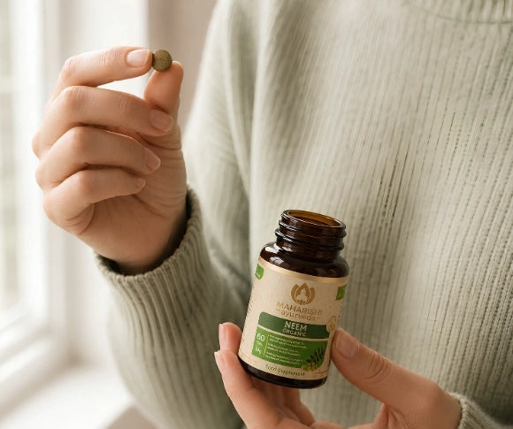 Person nimmt eine Neem Bio Tablette mit dem Neem-Produkt in der Hand